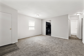 Indianapolis apartment for rent - Living room with carpets in a two-bedroom, one-bath Windsor Park apartment, featuring large windows.