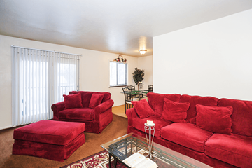 Bloomington apartment for rent - A living room with red furniture and a glass coffee table.
