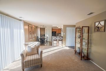 Fort Wayne apartment for rent - a living room with a couch and a chair and a kitchen in the background