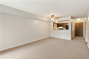 Bloomington apartment for rent - A spacious room with a ceiling fan and a small kitchenette.