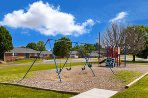 Bloomington apartment for rent - Colorful playground at Country View Apartments, featuring swings, slides, and play structures.