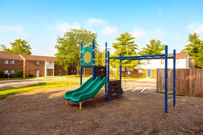 Bloomington apartment for rent - A playground with a green slide and a blue monkey bars.