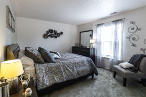 Mishawaka apartment for rent - a bedroom with a bed and a dresser and a window