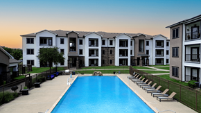 Sherman apartment for rent - A large swimming pool is surrounded by lounge chairs in front of apartment buildings.