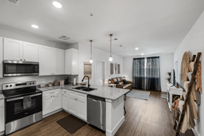 Athens apartment for rent - A modern kitchen with white cabinets and stainless steel appliances at Flat Creek Apartments in Athens TX.
