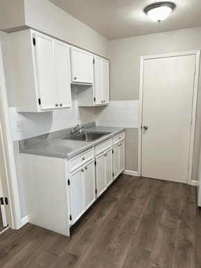 Shiloh apartment for rent - A kitchen with white cabinets and a wooden floor.
