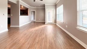 Palestine apartment for rent - A spacious room with wooden flooring and a ceiling fan.