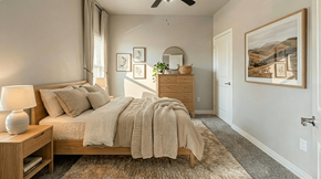 Palestine apartment for rent - A bedroom with a bed, nightstand, and a painting on the wall.