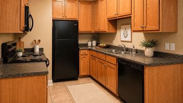 Sulphur Springs apartment for rent - A kitchen with wooden cabinets and black appliances.