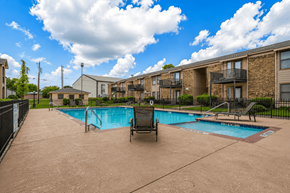 Sulphur Springs apartment for rent - A swimming pool in a residential area with a chair and a poolside table.