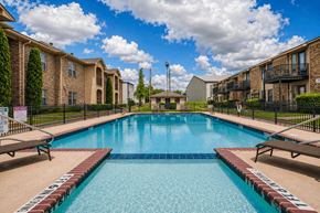 Sulphur Springs apartment for rent - A swimming pool surrounded by apartment buildings on a sunny day.