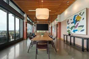 Seattle apartment for rent - A conference room with a long table and chairs, a television, and a large painting on the wall.