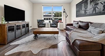 Tacoma apartment for rent - A living room with a brown leather couch and a wooden coffee table.