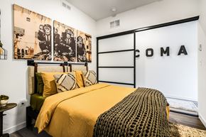 Tacoma apartment for rent - a bedroom with a bed with a yellow comforter and pillows and a black and