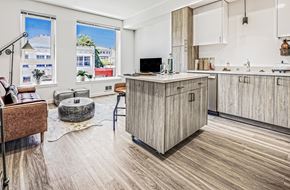 Tacoma apartment for rent - a kitchen with an island and a living room with a couch and a coffee table