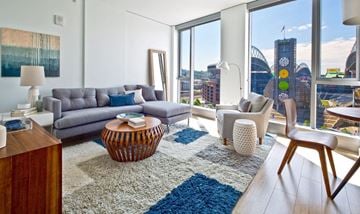 Seattle apartment for rent - A living room with a grey couch and a wooden table.