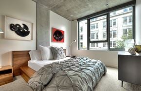 Seattle apartment for rent - Modern bedroom with concrete ceiling and city views at Stadium Place Apartments, Washington