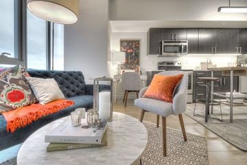 Seattle apartment for rent - a living room and kitchen with a blue couch and a table