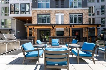 Seattle apartment for rent - A patio with blue chairs and a table with a blue cushion.