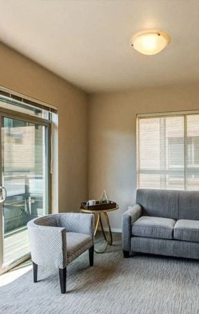 A living room with a grey couch, a chair, and a small table 