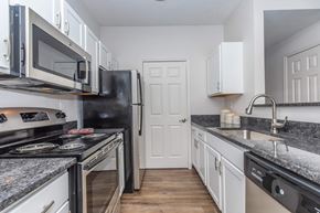 Aurora apartment for rent - a kitchen with granite counter tops and a stove and a refrigerator