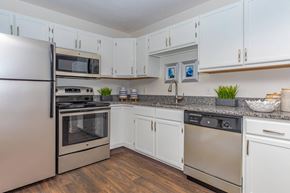 Avon apartment for rent - a kitchen with stainless steel appliances and white cabinets
