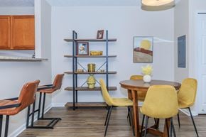 Kent apartment for rent - A dining room with a table surrounded by chairs and a shelf with decorative items.