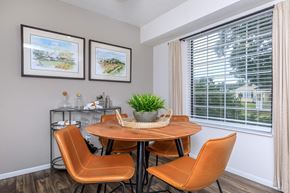 Westlake apartment for rent - A dining room with a round table and orange chairs.