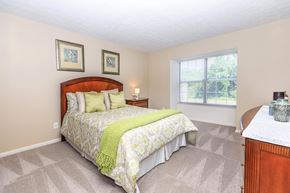 Aurora apartment for rent - A bedroom with a bed, nightstand, and two pictures on the wall.