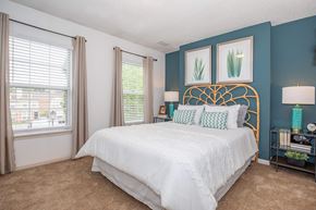 Sagamore Hills apartment for rent - A bedroom with a white bed and a gold headboard.