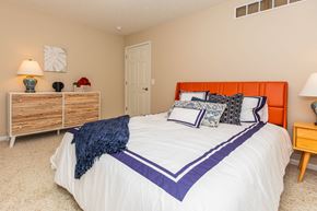 Sheffield Lake apartment for rent - A bedroom with a white bed and a wooden dresser.