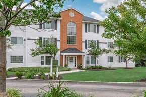 Brook Park apartment for rent - a white building with a red brick chimney and a sidewalk in front of it