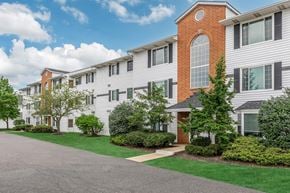 Brook Park apartment for rent - an exterior view of a building with green grass and trees