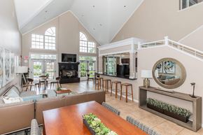 Beachwood apartment for rent - A large, well-lit living room with a fireplace and a long wooden table.