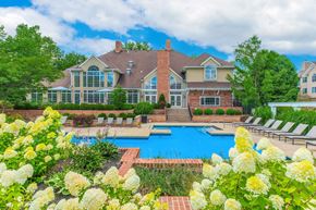 Beachwood apartment for rent - A large house with a pool and a garden in front.