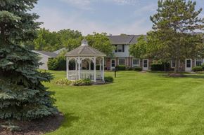 Westlake apartment for rent - A gazebo is in the middle of a grassy area in front of a house.