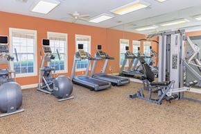 Cuyahoga Falls apartment for rent - A gym with orange walls and a variety of exercise equipment.
