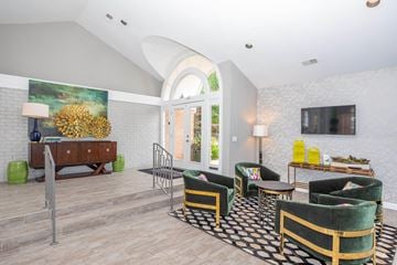 Sagamore Hills apartment for rent - A living room with a green and gold chair and a black and white rug.