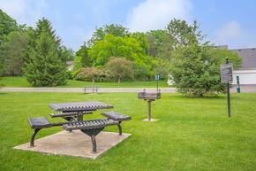 Streetsboro apartment for rent - a park with picnic tables and a sign in the grass