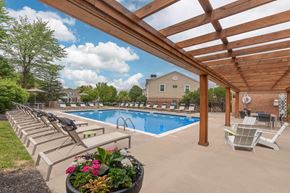 Sagamore Hills apartment for rent - A pool surrounded by a wooden pergola and lounge chairs.