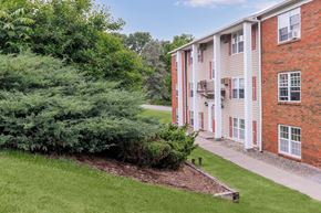Ithaca apartment for rent - the front of a brick building with a sidewalk and grass