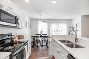 Medina townhouse for rent - A modern kitchen with white cabinets and a wooden floor.