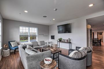 Niskayuna apartment for rent - A living room with grey couches and a flat screen TV mounted on the wall.