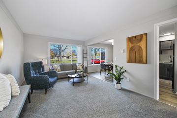 Harper Woods apartment for rent - A living room with a grey carpet and a grey sofa.