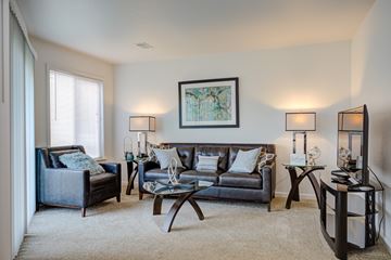Westland apartment for rent - A living room with a grey couch, a black chair, a coffee table, and a painting on the wall.
