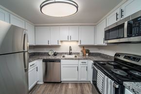 Southfield apartment for rent - A modern kitchen with white cabinets and stainless steel appliances.