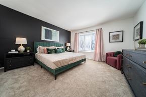 Southfield apartment for rent - A bedroom with a green bed and a red chair.