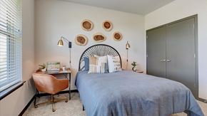 Mchenry apartment for rent - A bedroom with a bed, a chair, and a desk.