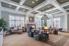Mechanicsburg townhouse for rent - A large, well-lit living room with a variety of seating options and a chandelier at Meridian West Shore, Pennsylvania 17055