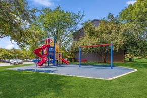 Naperville apartment for rent - A playground with a red slide and a blue swing set.